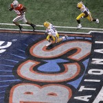 Ohio State running back Chris Wells, top left, starts his 65-yard touchdown run as LSU defenders Craig Steltz, center, and Curtis Taylor give chase in the first quarter during the BCS championship college football game at the Louisiana Superdome in New Orleans, Monday, Jan. 7, 2008. (AP Photo/Charlie Riedel)