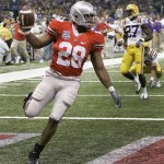 Ohio State running back Chris Wells (28) holds the ball up after scoring on a 65-yard run during the first quarter of the BCS championship college football game at the Louisiana Superdome in New Orleans, Monday, Jan. 7, 2008. In the background is LSU safety Curtis Taylor (27). (AP Photo/Chuck Burton)