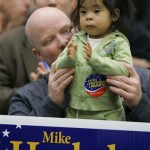 Mike Smith from Inman, S.C., holds his 19-month-old daughter Mia as she applaudes durung a campaign event for Republican presidential hopefu,l former Arkansas Gov. Mike Huckabee, in Spartanburg, S.C., Wednesday, Jan. 9, 2008. (AP Photo/Alex Brandon)