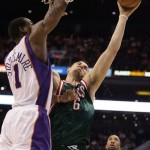 Milwaukee Bucks center Andrew Bogut, center, shoots over Phoenix Suns center Amare Stoudemire, left, as Suns forward Brian Skinner, right, looks on in the first quarter of an NBA basketball game Saturday, Jan. 11, 2008, in Phoenix. (AP Photo/Paul Connors)