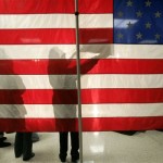 People wait behind an American flag for Democratic presidential hopeful former Sen. John Edwards, D-N.C., moments before a campaign event, in Myrtle Beach, S.C., Monday, Jan. 14, 2008. (AP Photo/Steven Senne)