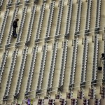 Workers sweep between seats in the University of Phoenix Stadium in preparation for Super Bowl XLII on Monday, Jan. 28, 2008 in Glendale, Ariz. The New England Patriots will play the New York Giants on Sunday, Feb. 3. (AP Photo/Charlie Riedel)