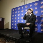 New York Giants quarterback Eli Manning is prepped for a television interview by sound man Michael Waugh on Monday, Jan. 28, 2008, in Chandler, Ariz. The Giants will play the New England Patriots in NFL football's Super Bowl XLII on Sunday. (AP Photo/Julie Jacobson)