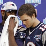 New England Patriots wide receiver Randy Moss wispers to Tom Brady (12) during media day for the Super Bowl XLII football game Tuesday, Jan. 29, 2008, in Glendale, Ariz,. (AP Photo/Stephan Savoia)