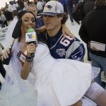 Ines Gomez Mont, a reporter from TV Azteca in Mexico, wears a wedding dress as she is carried by New England Patriots center Lonie Paxton while interviewing him during media day for the Super Bowl XLII football game Tuesday, Jan. 29, 2008, in Glendale, Ariz, Gomez Mont was in a wedding dress to ask Patriots quarterback Tom Brady to marry her. The Patriots will play the New York Giants in Super Bowl XLII on Sunday, Feb. 3. (AP Photo/The Arizona Republic, Michael Chow)
