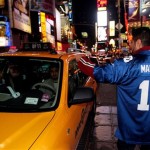 Jason Dukhi greets taxi drivers as he celebrates the New York Giants' Super Bowl XLII victory in Times Square Sunday, Feb. 3, 2008 in New York. (AP Photo/Gary He)