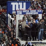Defensive end Michael Strahan, New York Mayor Michael Bloomberg, coach Tom Coughlin, and MVP quarterback Eli Manning, at the front of the float, from left, show off the Vince Lombardi Trophy to a throng of fans as the Super Bowl Champion New York Giants receive a ticker tape parade in Lower Manhattan through the "Canyon of Heroes" Tuesday, Feb. 5, 2008 in New York. (AP Photo/Jason DeCrow)
