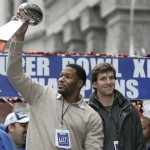New York Giants' quarterback Eli Manning looks on as defensive end Michael Strahan, holds the Super Bowl trophy during a parade celebrating the New York Giants Super Bowl victory over the New England Patriots Tuesday, Feb. 5, 2008 in New York. (AP Photo/Frank Franklin II)
