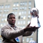 New York Giants defensive end Michael Strahan shows the Vince Lombardi Trophy as he rides through the Super Bowl victory parade Tuesday, Feb. 5, 2008 in New York. (AP Photo/Gary He)
