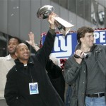 New York Giants general manager Jerry Reese, center, holds the Vince Lombardi trophy as Eli Manning, right, and Michael Strahan, left, wave to fans during a parade celebrating the Giants Super Bowl victory over the New England Patriots Tuesday, Feb. 5, 2008 in New York. (AP Photo/Frank Franklin II)
