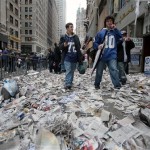 Football fans walk through the confetti strewn on Broadway after the New York Giants' Super Bowl victory parade Tuesday, Feb. 5, 2008 in New York. (AP Photo/Gary He)
