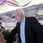 Republican presidential hopeful Sen. John McCain, R-Ariz., works the aisle as his charter plane is decorated with red, white, and blue streamers the morning after the Super Tuesday primary elections Wednesday, Feb. 6, 2008, in Phoenix, Ariz. (AP Photo/Charles Dharapak)