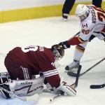 Calgary Flames' Kristian Huselius, right, of Sweden, has his shot on goal blocked by Phoenix Coyotes goalie Ilya Bryzgalov during the first period of an NHL Hockey game Tuesday, Feb. 19, 2008, in Glendale, Ariz. (AP Photo/Roy Dabner)