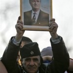A protester holds a picture of the former Bosnian Serb leader Radovan Karadzic, during a mass protest rally against Kosovo's declaration of independence in Belgrade, Serbia, Thursday, Feb. 21, 2008. At least 150,000 Serbs gathered in central Belgrade on Thursday in a massive protest against Kosovo's declaration of independence, raising fears of street violence. (AP Photo/Darko Vojinovic)