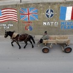 A Kosovar man drives a horse cart past graffiti drawn on a wall in eastern Kosovo town of Gnjilane on Tuesday, Feb. 19, 2008. Kosovo declared independence from Serbia over the weekend and was swiftly recognized by the U.S. and Europe's major powers, but the new country has run into opposition from Russia and several nations in the EU that oppose Kosovo's becoming a state. (AP Photo/Visar Kryeziu)
