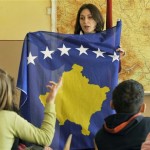 Kosovar Albanian teacher Luljeta Rama introduces Kosovo's new national flag to her class, on the first school day after Kosovo declared its independence, on the Albanian side of the ethnically divided town of Kosovska Mitrovica, Kosovo, Tuesday, Feb. 19, 2008. The predominantly ethnic Albanian leadership of Kosovo, Serbia's medieval heartland, proclaimed independence from Serbia Sunday with Western backing. Serbia lost control over Kosovo, whose two-million population is 90 percent Albanian, since NATO bombing drove out Serb forces in 1999 to halt their killing and ethnic cleansing in a two-year war against separatist rebels. (AP Photo/Bela Szandelszky)
