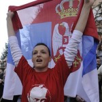 A Serb student wearing a tee-shirt showing Russian president Vladimir Putin raises a Serbian flag while protesting against Kosovo's independence in the ethnically divided town of Kosovska Mitrovica, Kosovo, Thursday, Feb. 21, 2008. Kosovo's predominantly Albanian leadership proclaimed independence from Serbia with western backing on Sunday while Serbia's strongest ally, Russia opposed any declaration. The proclamation of the independence was followed with a growing anger among Kosovo's Serb population. (AP Photo/Bela Szandelszky)