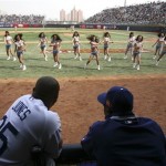 Los Angeles Dodgers' Andruw Jones, left, and an unidentified player watch cheerleaders perform during an exhibition baseball game against the San Diego Padres, Sunday, March 16, 2008, in Beijing, China. (AP Photo/Robert F. Bukaty)