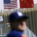 American and Chinese flags fly at Wukesong Baseball Field before the start of an exhibition game between the Los Angeles Dodgers and the San Diego Padres, Saturday, March 15, 2008, in Beijing, China. A Dodgers coach is seen in the foreground. (AP Photo/Robert F. Bukaty)