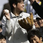 A baseball fan shows off a ball he caught during an exhibition game between the Los Angeles Dodgers and the San Diego Padres, Saturday, March 15, 2008, in Beijing, China. (AP Photo/Robert F. Bukaty)