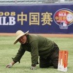 A worker picks gravel from the centerfield turf while preparing for this weekend's Major League Baseball series at Wukesong Baseball Field in Beijing, China, Wednesday, March 12, 2008. The Los Angeles Dodgers will play the San Diego Padres on Saturday and Sunday. Wukesong Baseball Field is a venue for the 2008 Beijing Olympics. (AP Photo/Robert F. Bukaty)