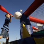 Tyler Corsi, 8, of Painesville, Ohio, plays an arcade-style game before an spring training baseball game between the Arizona Diamondbacks and the Seattle Mariners in Peoria, Ariz., Wednesday, March 19, 2008. (AP Photo/Chris Carlson)
