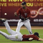 Arizona Diamondbacks center fielder Chris Young, top, and shortstop Stephen Drew can't get a glove on a RBI-single by Seattle Mariners' Brad Wilkerson in the first inning during a spring training baseball game in Peoria, Ariz., Wednesday, March 19, 2008. (AP Photo/Chris Carlson)