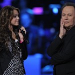Billy Crystal, right, and Miley Ray Cyrus are seen on stage at the "Idol Gives Back" fundraising special of "American Idol" in Los Angeles on Sunday April 6, 2008. (AP Photo/Mark J. Terrill)