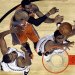 Phoenix Suns forward Amare Stoudemire, top, is defended by San Antonio Spurs forward Tim Duncan, right, and forward Kurt Thomas, left, during the first quarter in Game 1 of an NBA Western Conference basketball playoff series in San Antonio, Saturday, April 19, 2009. (AP Photo/Eric Gay)