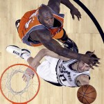 San Antonio Spurs guard Manu Ginobili, bottom, of Argentina,is defended by Phoenix Suns center Shaquille O'Neal (32) during the second half in Game 1 of their Western Conference playoff basketball series in San Antonio, Saturday, April 19, 2009. San Antonio won 117-115 in double-overtime.(AP Photo/Eric Gay)