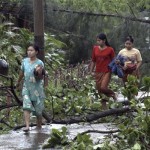 Residents make their way through fallen trees Sunday, May 4, 2008, following cyclone Nargis. The death toll from the devastating cyclone has risen to almost 4,000, a Myanmar state radio station has said. The radio station broadcasting from the country's capital Naypyitaw said Monday that almost 3,000 more people are unaccounted for in a single town in the country's low-lying Irrawaddy River delta area. (AP Photo/Barry Broman)