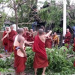 In this photo released by China's Xinhua News Agency, monks clear up roads damaged by cyclone in Yangon, Sunday, May 4, 2008. Residents of Myanmar's biggest city lit candles Monday, May 5, lined up to buy water and hacked their way through trees fallen in a cyclone that killed more than 350 people, destroyed thousands of homes and caused widespread power cuts. (AP Photo/Xinhua, Zhang Yunfei)