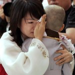 A mother wipes tears as she hugs her son having head shaved during a ritual to celebrate Buddha's upcoming birthday on May 12 at the Chogye temple in Seoul Thursday, May 1, 2008. Eight children entered the temple to have an experience of monks' life for a month. (AP Photo/Lee Jin-man)