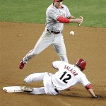 Philadelphia Phillies' Chase Utley, top, forces out Arizona Diamondbacks' Jeff Salazar (12) during a double play in the sixth inning of a baseball game Wednesday, May 7, 2008 in Phoenix. (AP Photo/Matt York)