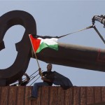 A man waves a Palestinian flag in front of a nine-meter metal key, representing the keys to the houses Palestinian refugees left in 1948, a symbol for the right of refugees to return, in the West Bank town of Bethlehem, Thursday, May 8, 2008. Israel is marking the 60th anniversary of the founding of the state Thursday. Palestinians see the founding of the Jewish state as a tragic event which they call al-Naqba, Arabic for "the catastrophe."(AP Photo/Ed Ou)

