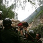 Rescuers carry a wounded woman out of the debris of a collapsed building after the earthquake at Beichuan County in Mianyang of southwest China's Sichuan province, Tuesday, May 13, 2008. The official death toll after Monday's powerful 7.9 magnitude earthquake rose Tuesday to nearly 12,000, and thousands remain buried or missing.(AP Photo/Color China Photo)