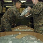 In this picture provided by the U.S. Navy, U.S. Marine Corps Lance Cpl. Eric Clamor, left, and Sgt. James McCarty, both assigned to the 31st Marine Expeditionary Unit, fill five-gallon bags of drinking water in the upper vehicle storage space of the USS Essex in the South China Sea en route to Myanmar for possible distribution to victims of Cyclone Nargis. (AP Photo/U.S. Navy, Mass Communication Specialist 3rd Class Gabriel S. Weber)
