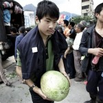A Chinese boy receives fruit which is being distributed by volunteers near a shelter following Monday's powerful 7.9 magnitude earthquake in Hanwang town in Sichuan province, China, Wednesday, May 14, 2008. (AP Photo/Andy Wong)
