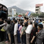 Chinese locals line up to receive fruit distributed by volunteers following Monday's powerful 7.9 magnitude earthquake in Hanwang town in Sichuan province, China, Wednesday, May 14, 2008. (AP Photo/Andy Wong)