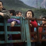 Earthquake survivors stand in a truck as they are transferred to a temporary shelter following Monday's powerful 7.9 magnitude earthquake in Mianyang City in Sichuan province, China, Wednesday, May 14, 2008. (AP Photo/Andy Wong)
