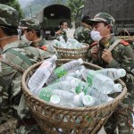 People's Armed Police rescue workers carry bottled drinking water to distribute to quake survivors in hard-hit Beichuan county, Mianyang city, Sichuan province, China, Thursday, May 15, 2008. China warned the death toll from this week's earthquake could soar to 50,000, while the government issued a rare public appeal Thursday for rescue equipment as it struggled to cope with the disaster. (AP Photo/Kyodo News, Takanori Sekine)