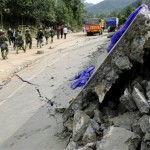 Rescue workers walk along a road destroyed by a devastating earthquake in hard-hit Beichuan county, Mianyang city, Sichuan province, China, Thursday afternoon, May 15, 2008. China warned the death toll from this week's earthquake could soar to 50,000, while the government issued a rare public appeal Thursday for rescue equipment as it struggled to cope with the disaster. (AP Photo/Kyodo News, Takanori Sekine)