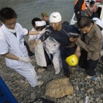 An injured earthquake victim is assisted by medical workers after arriving on a boat from areas inaccessible by road at the Zipingpu Dam near Dujiangyan, southwestern China's Sichuan province, Thursday, May 15, 2008. China warned the death toll from this week's earthquake could soar to 50,000, while the government issued a rare public appeal Thursday for rescue equipment as it struggled to cope with the disaster. (AP Photo/Ng Han Guan)
