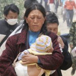 A local resident carries a baby on the way to a shelter after Monday's powerful earthquake in Mianyang in southwestern Chinese province of Sichuan Friday, May 16, 2008. A strong aftershock sparked landslides Friday near the epicenter of this week's powerful earthquake, burying vehicles and again cutting off ravaged areas of central China. (AP Photo/Kyodo News)