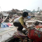 A girl searches for her schoolbag in the debris of collapsed buildings in earthquake-hit Mianzhu of southwest China's Sichuan province, Friday, May 16, 2008. China struggled to bury its dead and help tens of thousands of injured and homeless on Friday when a powerful aftershock brought new havoc four days after an earthquake thought to have killed more than 50,000. (AP Photo/Color China Photo)