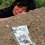 A woman grieves on the grave of her child who was killed in Monday's earthquake at a school in Wufu, in China's southwest Sichuan province Friday May 16, 2008. Most of the students killed when Wufu's school collapsed were only children, deepening the pain of parents who stuck to China's one-child policy. Parents complained that the school was shoddily built - a common allegation with almost 7000 schoolrooms destroyed in the earthquake. (AP Photo/Greg Baker)
