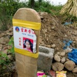 The damaged school ID card of a young girl who was killed when her schoolroom collapsed in Monday's earthquake, is seen at her grave in Wufu, in China's southwest Sichuan province Friday May 16, 2008. Most of the students killed when Wufu's school collapsed were only children, deepening the pain of parents who had stuck to China's one-child policy. Parents complained that the school was shoddily built, a common allegation with almost 7,000 schoolrooms destroyed in the earthquake. (AP Photo/Greg Baker)