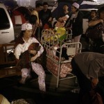 A woman wearing pyjamas holds her baby as she sits on a chair in the open-air after being evacuated with others from their homes for safety reasons, after they were warned to expect an earthquake aftershock in Mianyang, Southwestern Sichuan province, China, Monday, May 19, 2008. Chinese authorities on late Monday warned of a predicted large magnitude aftershock which they say will hit Sichuan province.(AP Photo/Andy Wong)