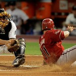 Arizona Diamondbacks' Augie Ojeda (11) slides safely into home plate as Florida Marlins catcher Matt Treanor is late on the tag in the fourth inning of a baseball game in Miami, Tuesday, May 20, 2008. Ojeda scored on a sacrifice fly by Conor Jackson. (AP Photo/Alan Diaz)