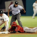 Arizona Diamondbacks' Orlando Hudson slides safely into second base after hitting a double as Florida Marlins second baseman Dan Uggla, left, makes a late tag in the sixth inning of a baseball game in Miami, Tuesday, May 20, 2008. Second base umpire Dan Iassogna, background watches the play. The Marlins won 3-2. (AP Photo/Alan Diaz)